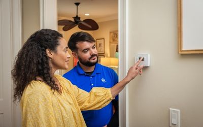 Woman and man in front of thermostat
